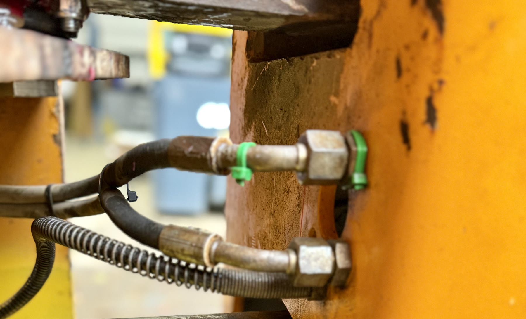 Hydraulic hose valves and fittings on yellow plant machinery